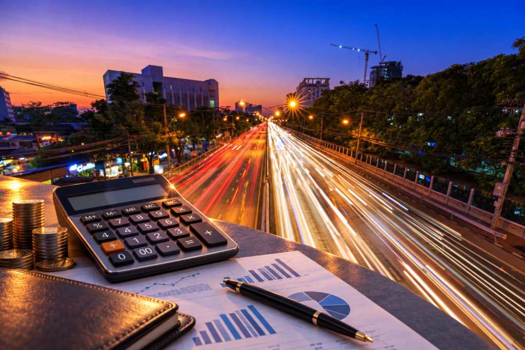 Imagem apresenta cidade movimentada, destacando-se itens do mercado financeiro